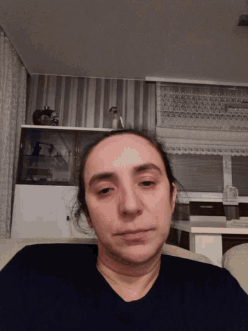 a woman 's face is shown upside down in front of a shelf