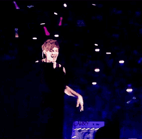 a man stands on a stage with a sign that says yo toute pleas