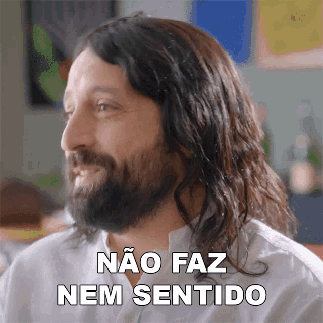 a man with long hair and a beard is smiling and says " não faz nem sentido "