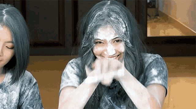 a woman with powder on her face is smiling with her eyes closed
