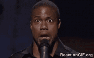 a man is standing in front of a microphone making a funny face .