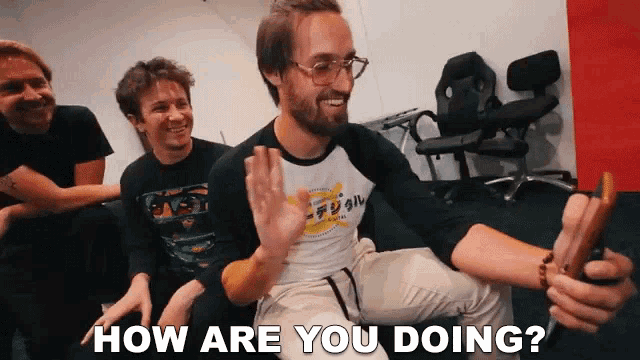 a group of men are sitting on a couch and one of them is holding a stick and says how are you doing