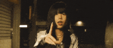 a woman wearing a leather jacket is standing in the dark