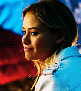 a close up of a woman 's face with a blue light behind her