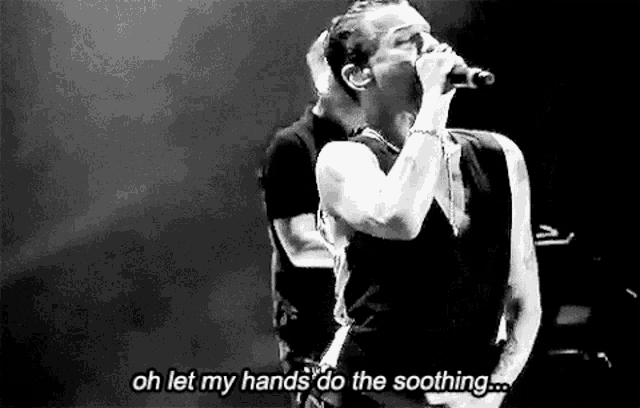 a black and white photo of a man singing into a microphone with the words `` oh let my hands do the soothing '' .