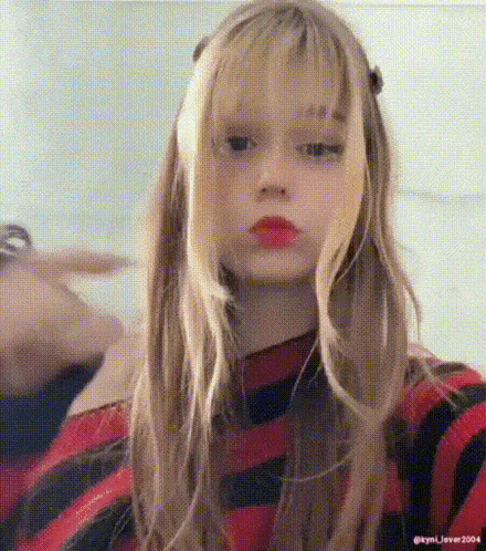 a girl with long blonde hair and red lips is wearing a red and black striped sweater .