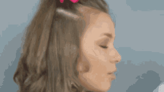 a close up of a woman 's face with a nose ring and earrings .
