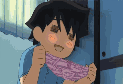 a boy in a blue shirt is holding a pair of pink underwear in his hands .
