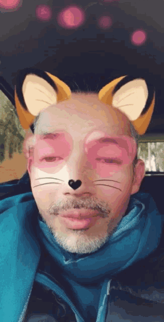 a man with a beard and a scarf has a cat mask on his face