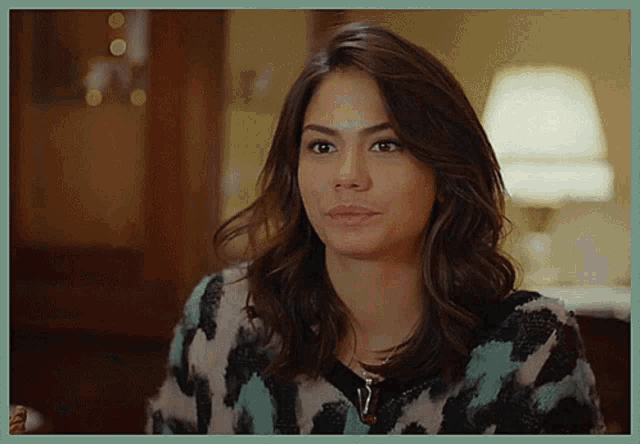 a woman is wearing a sweater with a leopard print