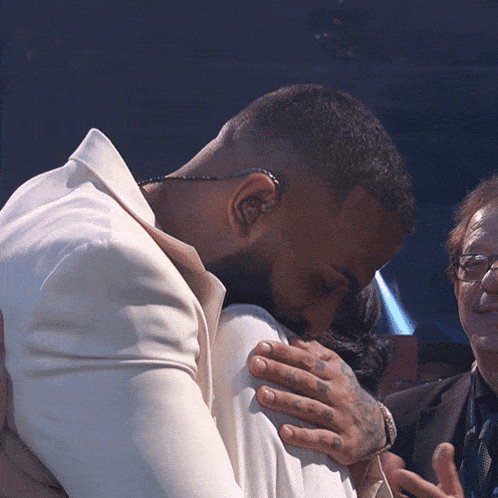 a man with a beard is hugging a woman