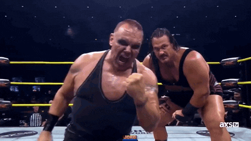 two men in a wrestling ring with axstv written on the bottom right