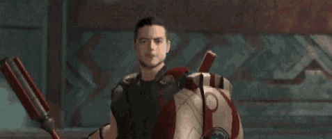 a man is holding a spear and a shield with a red and white stripe on it