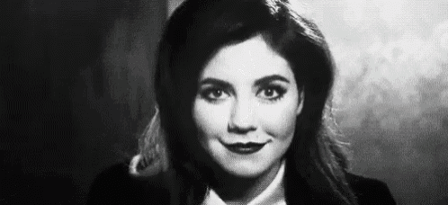 a black and white photo of a woman in a tuxedo and bow tie .