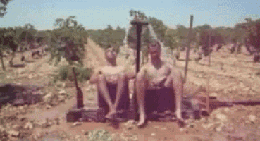 a blurred image of two men sitting in the dirt