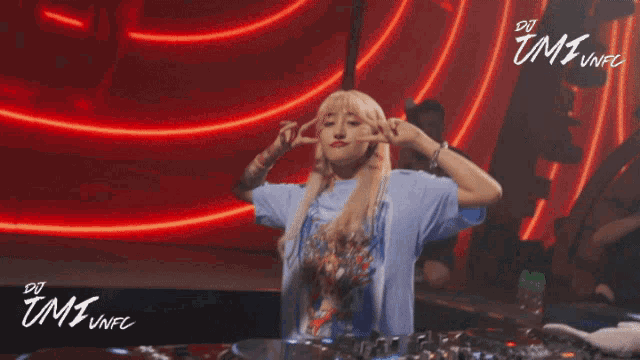 a woman dancing in front of a sign that says dj umi