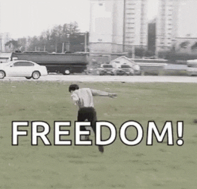 a man is running through a grassy field with the word freedom written on the ground .