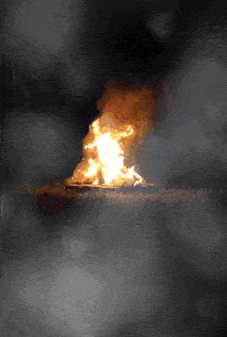a large fire is burning in the dark with a lot of smoke coming out of it