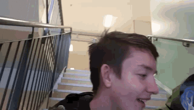 a young man is standing on a set of stairs looking at something