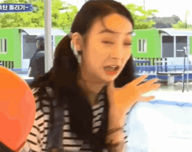 a woman in a striped shirt is making a funny face .