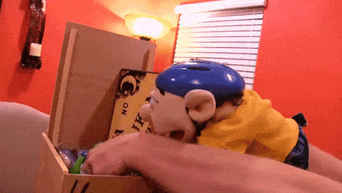 a person is putting a toy in a box with a ouija board on it