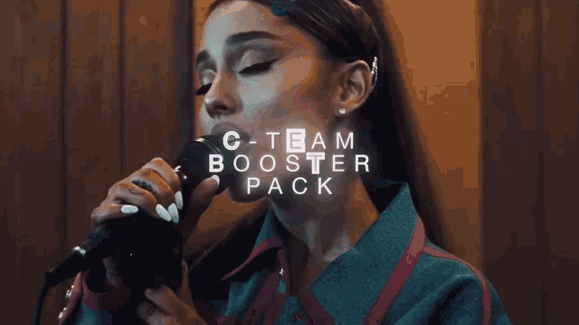 a woman singing into a microphone with the words o-team booster pack behind her