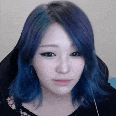 a close up of a woman 's face with blue and purple hair