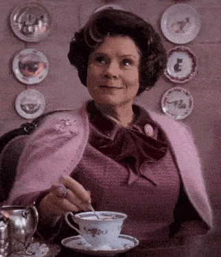 a woman sitting at a table with a cup of tea