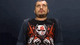 a man with a beard wearing a black shirt with a batman on it .