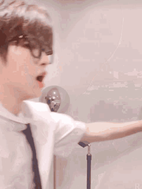 a blurry picture of a man wearing glasses and a white shirt .