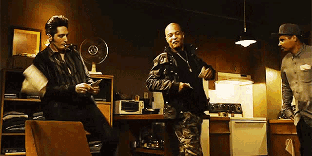 a group of men are dancing in a kitchen and one of them is holding a gun