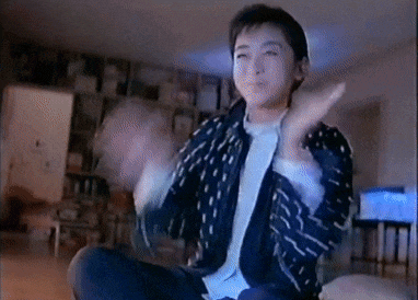 a young boy is sitting on a couch in a living room making a funny face .