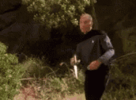 a man is standing in front of a tree with his arms outstretched and a blurry background .