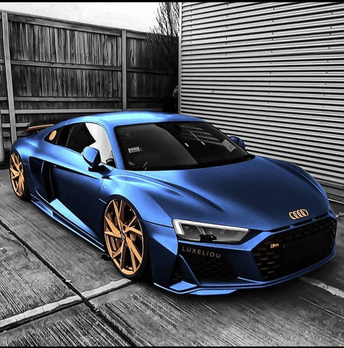 a blue audi sports car is parked in front of a garage
