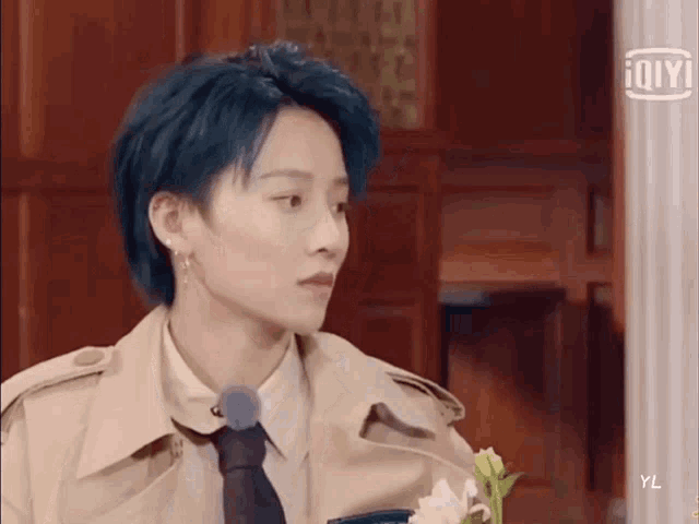 a girl with blue hair is wearing a trench coat and tie