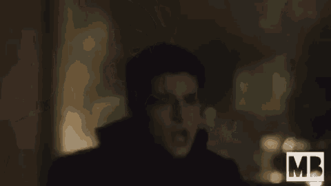 a man in a black coat is standing in the dark and says jeremiah aaah !