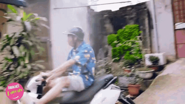 a man is riding a scooter with a pink sticker that says laugh on it