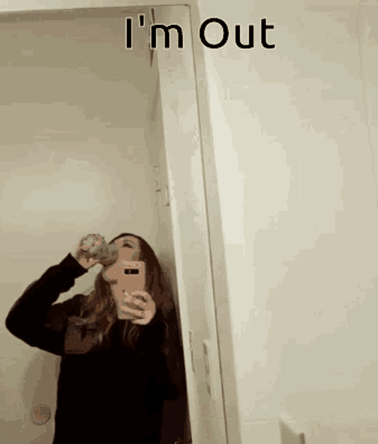 a woman drinking from a bottle in front of a mirror with the words i 'm out below her