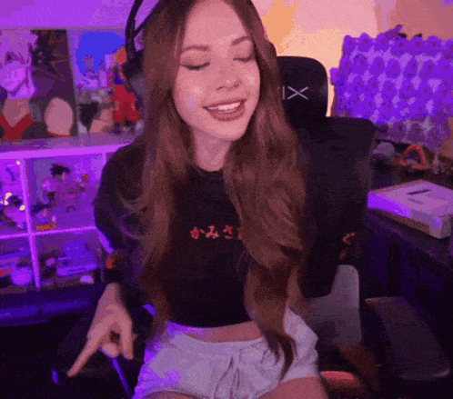 a woman wearing headphones and a crop top with the letter x on the back