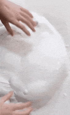 a person 's hands are reaching into a white substance