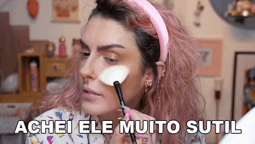 a woman with pink hair is applying makeup to her face with the words achei ele muito sutil written below her