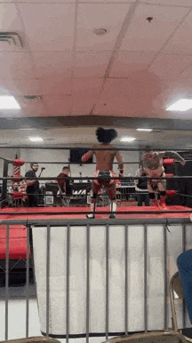 a man is standing in a boxing ring with a woman in a ring .
