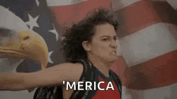 a woman is standing in front of an american flag with a bald eagle on it .