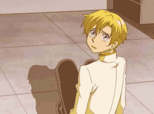 a boy with yellow hair and purple eyes is sitting on a chair