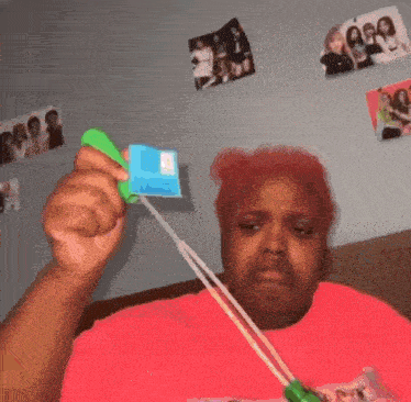 a woman blowing soap bubbles in front of a wall with pictures of a girl named asa