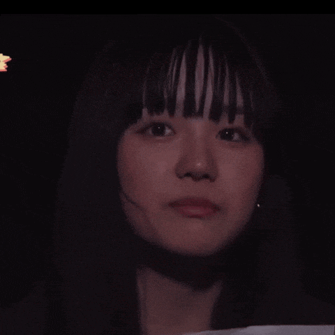 a close up of a woman 's face in the dark with a star in the background