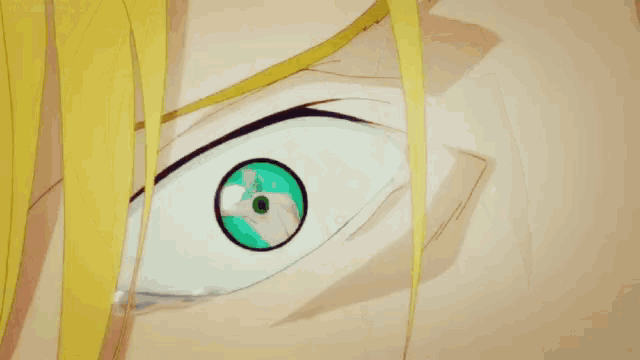 a close up of a man 's face with yellow hair and green eyes making a funny face .
