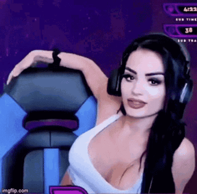 a woman in a white tank top and headphones is sitting in a chair .