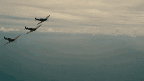 three planes are flying in a row in a cloudy sky