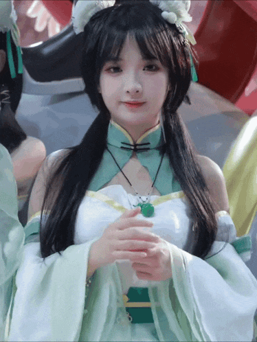 a girl in a green and white costume with a green pendant